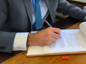 Man in gray suit signing documents